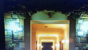 A hallway with a stone wall on one side and a wooden door at the end. - Gloria Tibi Hotel Gumbet (Bodrum)