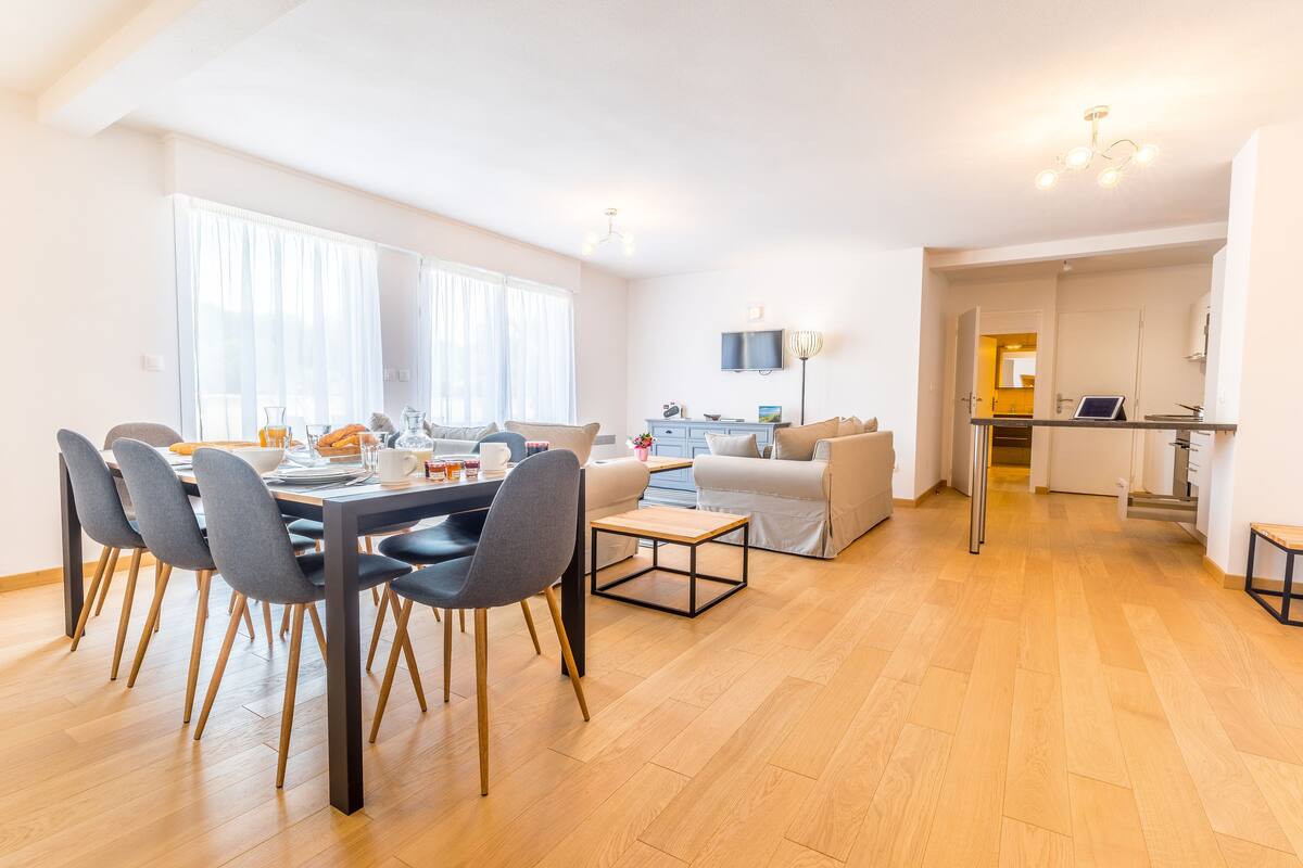 A modern apartment with a dining area, a living room, and a kitchen.