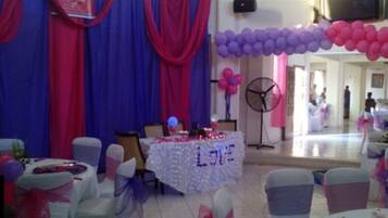 A decorated indoor space with a table labeled "LOVE" and balloons.
