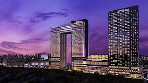 A modern hotel with a distinctive arch structure, multiple floors, and illuminated signage. - Novotel Ambassador Seoul Yongsan - Seoul Dragon City (Seoul)