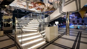 A modern hotel interior with a glass staircase, a reception desk, and a lounge area with seating. - Novotel Ambassador Seoul Yongsan - Seoul Dragon City (Seoul)