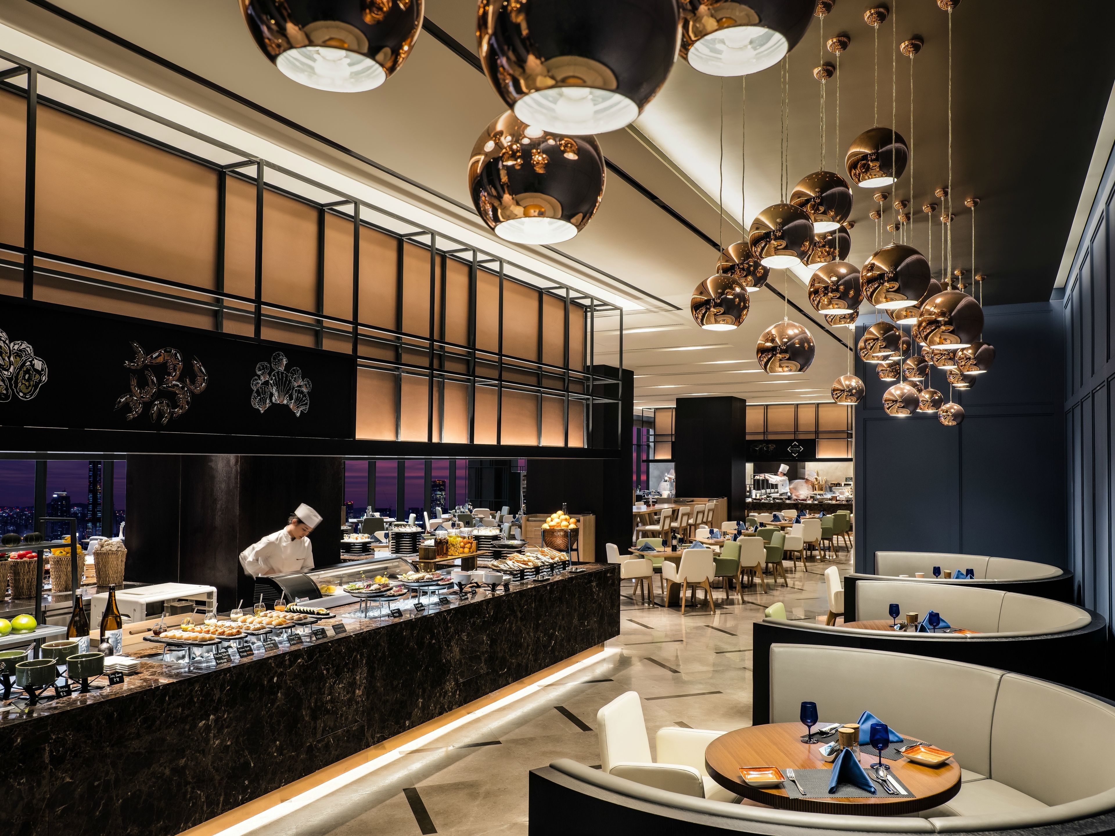 A modern hotel lobby with a marble reception desk, seating areas, and a view of the cityscape.
