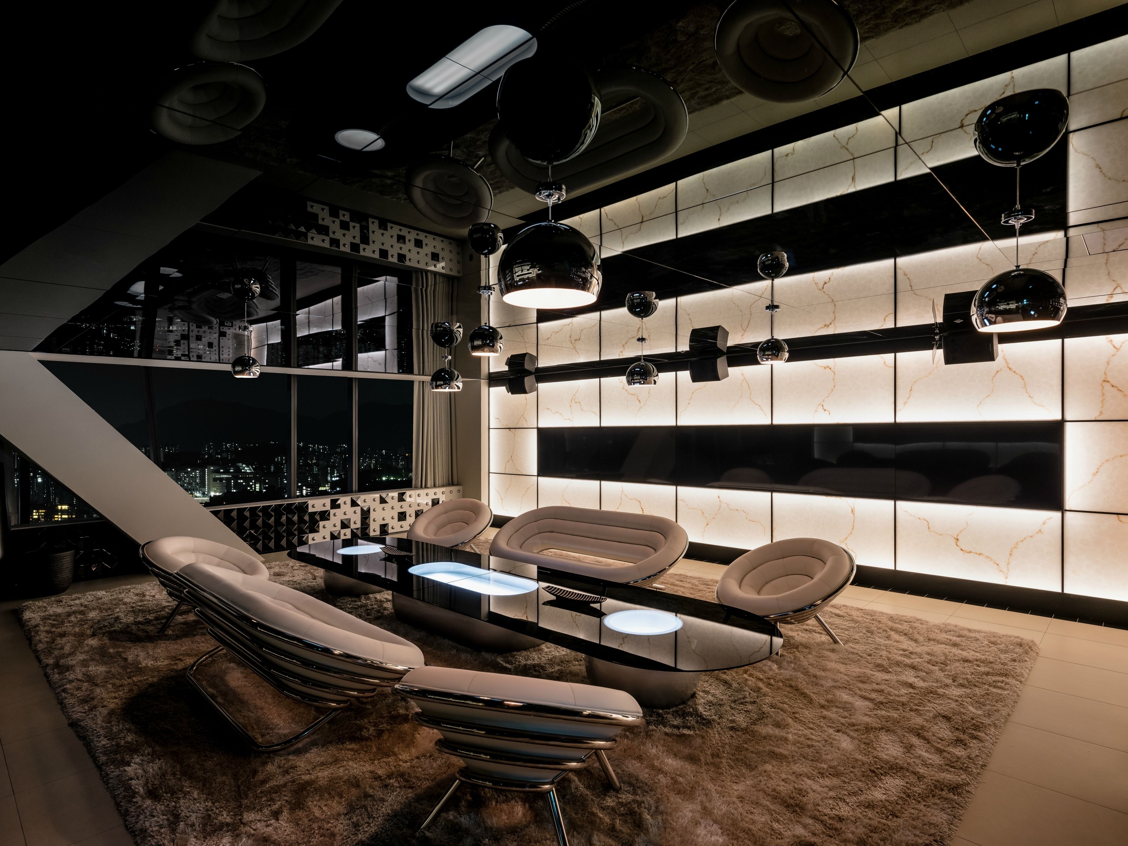 A modern lounge with a city view, sleek furniture, and ambient lighting.