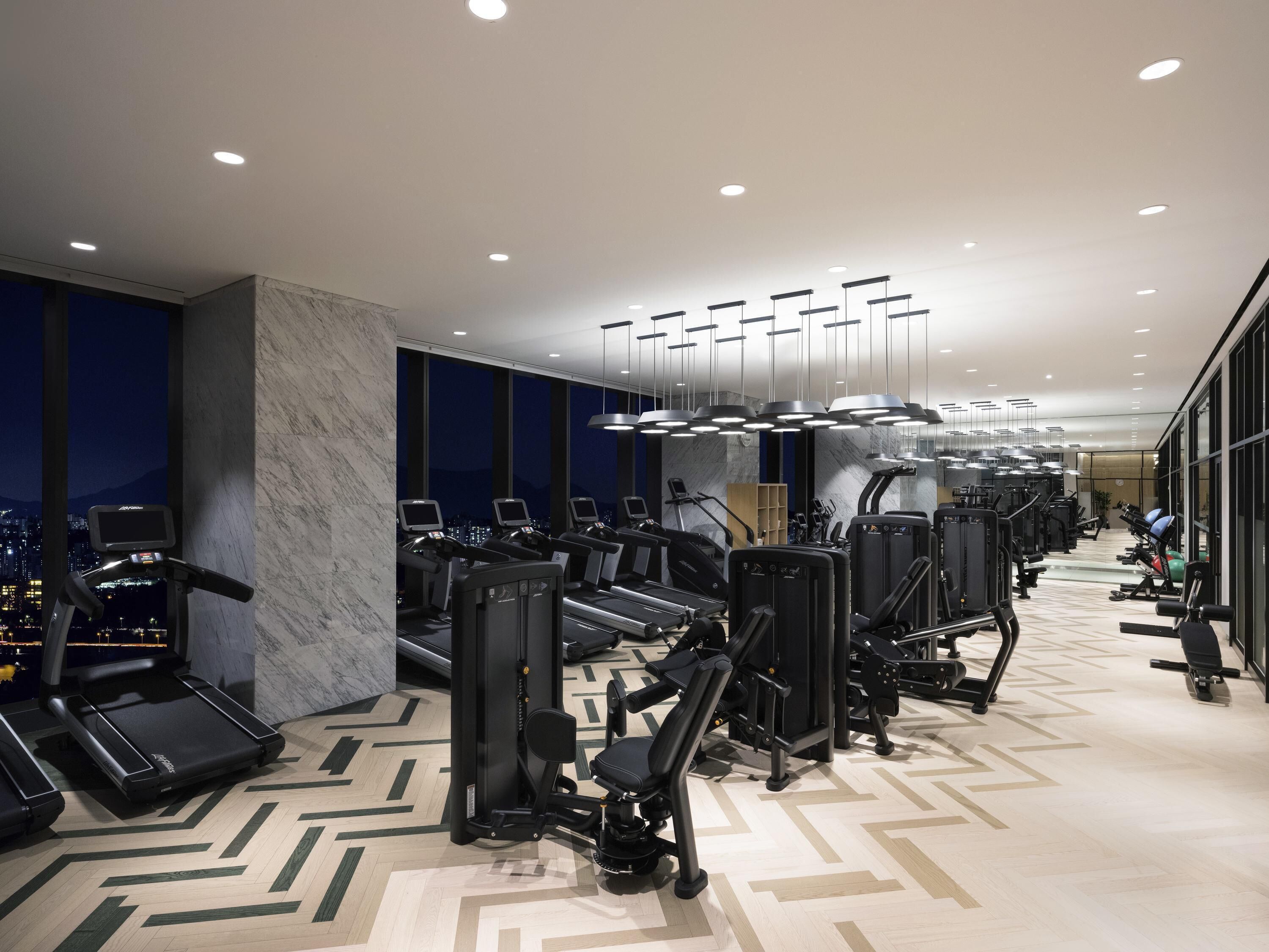 Een moderne sportschool met loopbanden, elliptische trainers en gewichten.