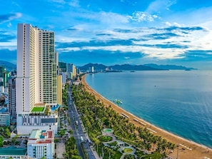 A coastal cityscape with a prominent high-rise hotel, a beach, and a clear view of the sea. - ibis Styles Nha Trang (Nha Trang)