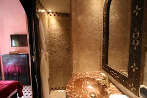 A bathroom with a marble sink, a large mirror with ornate frame, and a shower area with patterned tiles. - Maison Africa (Marrakech)