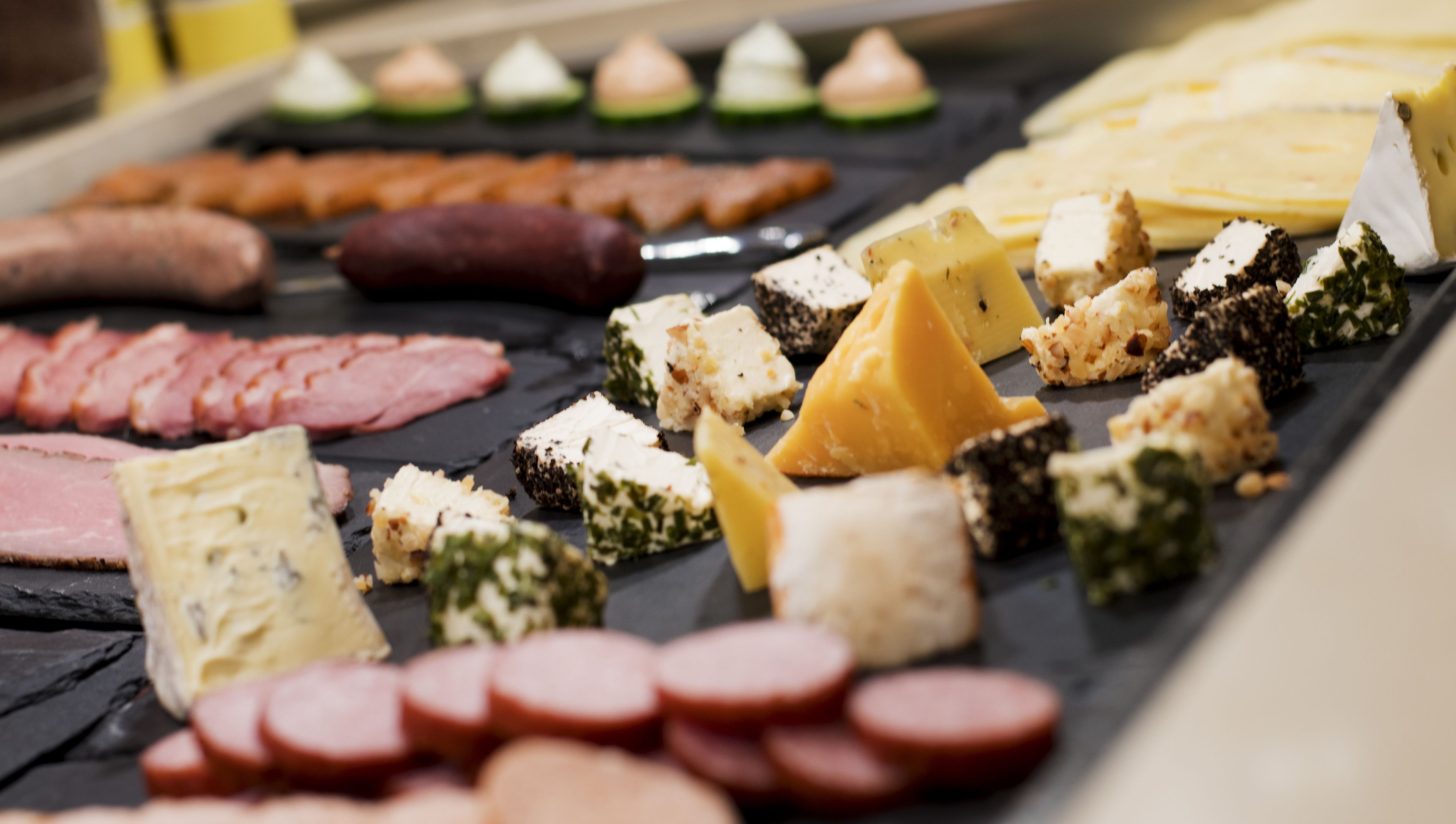 A variety of cheeses and meats on a board.