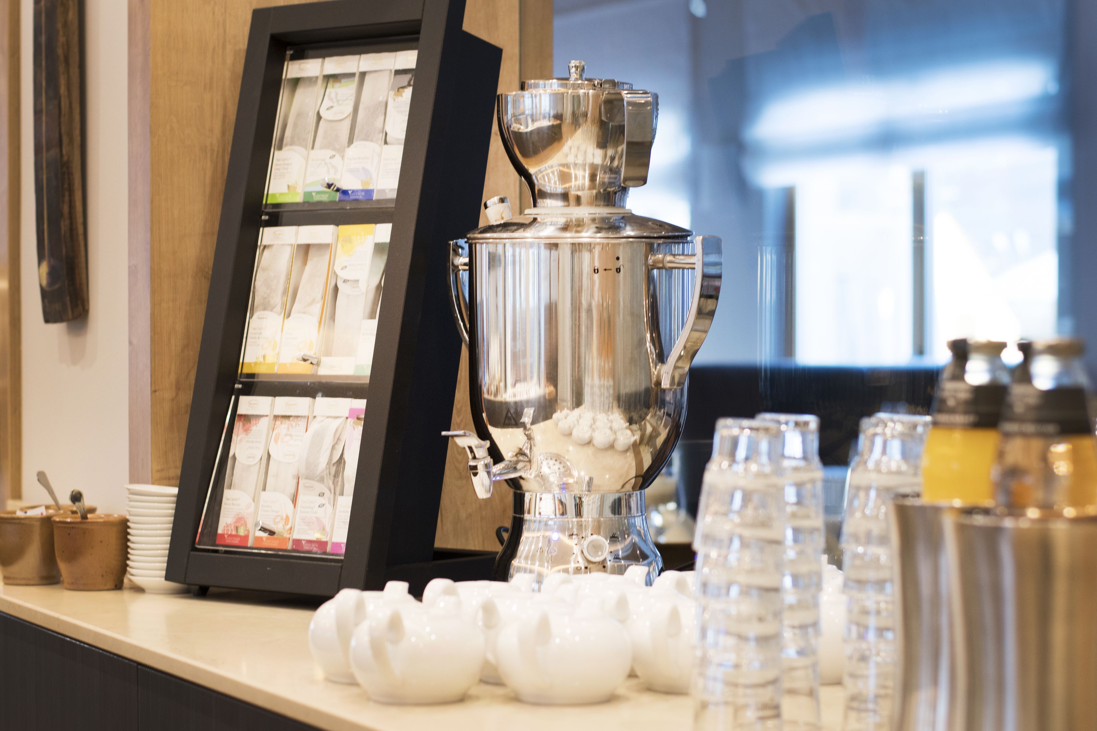 A coffee station with a coffee machine, tea bags, and sugar cubes.