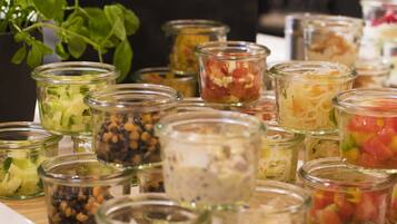 Verschillende soorten eten in kleine glazen potjes, waaronder ingelegde groenten en salades.