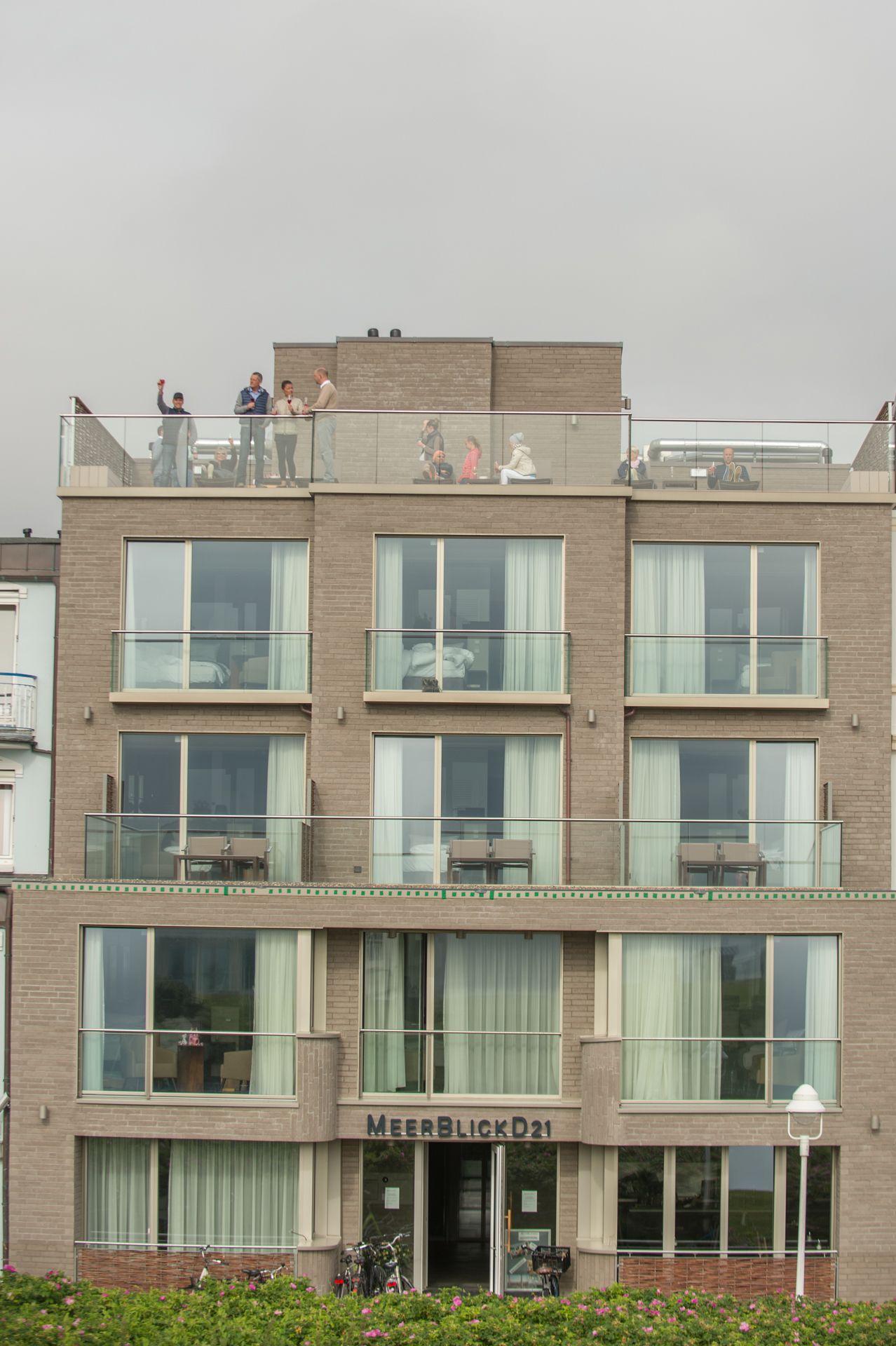 Un edificio de varios pisos con una entrada visible que dice "MEERBLICKD21".
