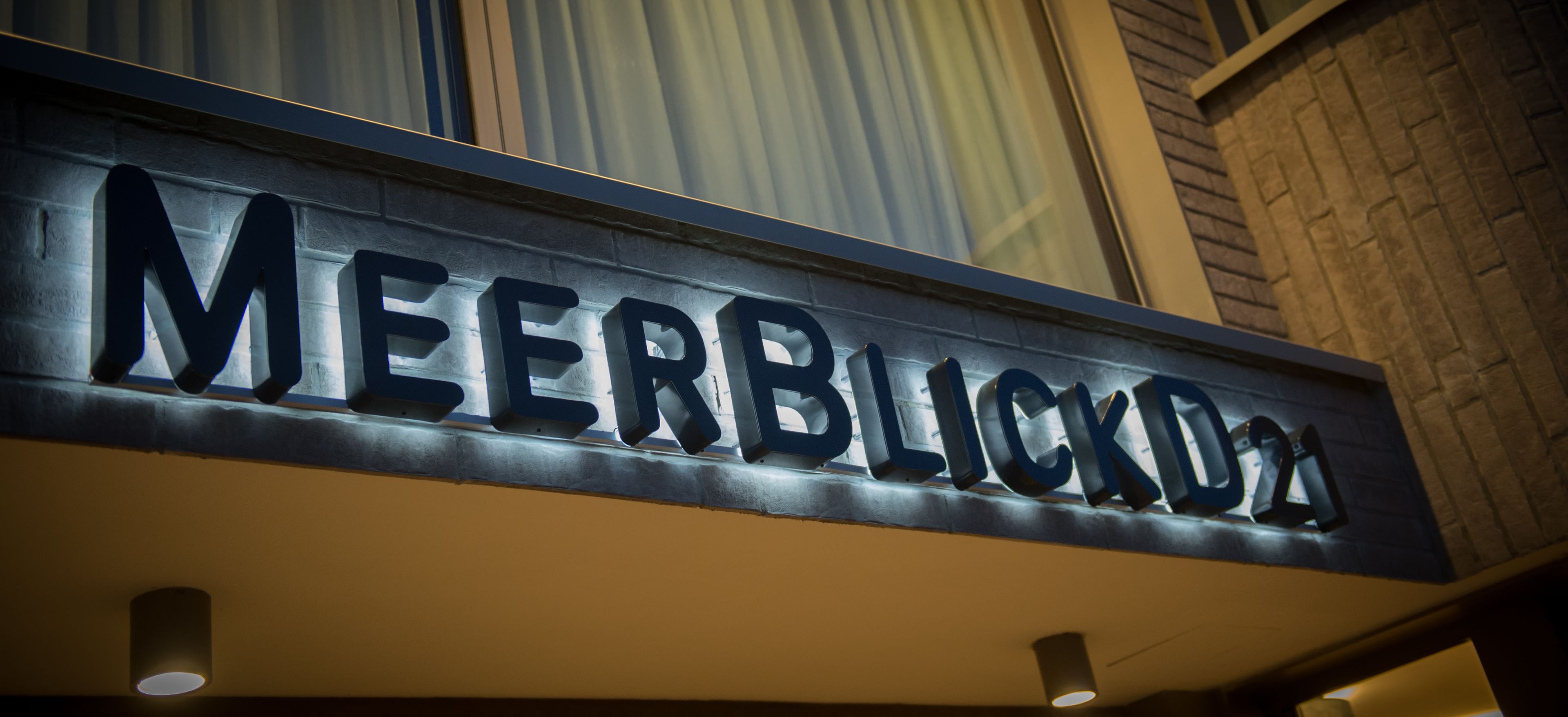 A sign with the name "MEERBLICK" on a building facade.