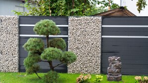 A landscaped garden with a bonsai tree, a rock wall, and a water feature. - Kreis Residenz München (Munich)