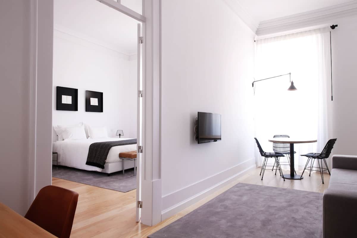 Une chambre d’hôtel moderne équipée d’un lit, d’un bureau et d’un coin repas.