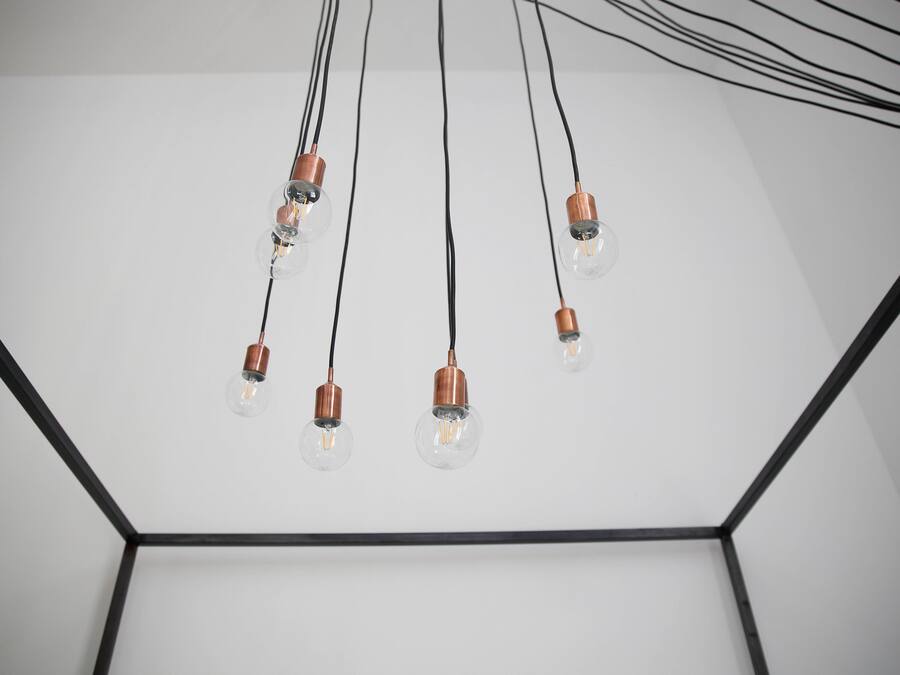 A ceiling with multiple light fixtures and exposed wiring.
