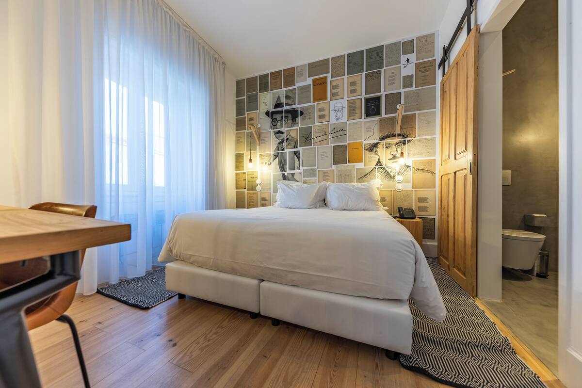 Une chambre moderne avec un lit, un bureau et un mur décoré de photos et de notes.