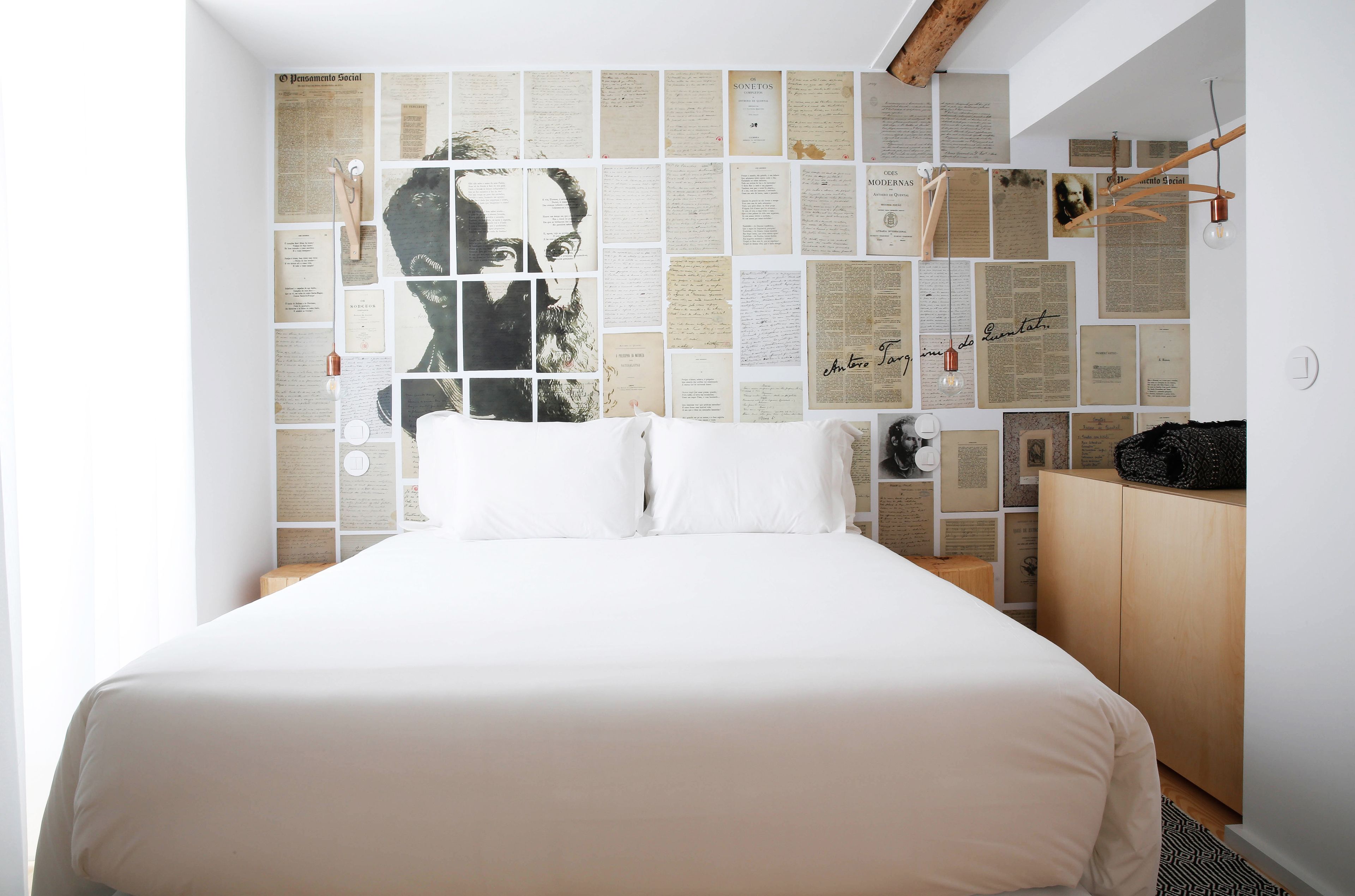 Ein Schlafzimmer mit einem großen Bett, einem Holzschrank und einer Wand voller verschiedener Papiere und Dokumente.