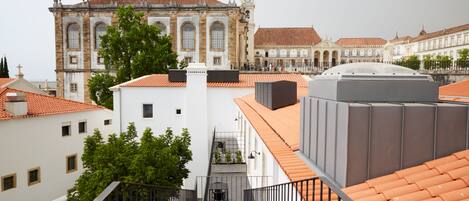 Vista de un edificio con techo de tejas y una escalera que conduce a un balcón.