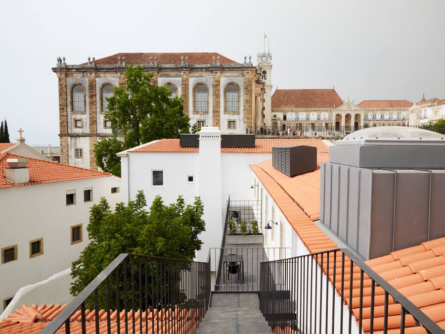 A view of a building with a tiled roof and a staircase leading to a balcony.