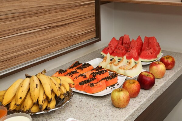 A breakfast buffet with sliced watermelon, bananas, apples, and papaya. - Big Hotel (Araguari)