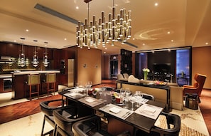 A modern hotel dining area with a long table set for a meal, a bar, and a seating area with a view. - HUALUXE Wuxi Taihu by IHG (Wuxi)