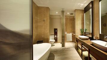 A modern bathroom with a bathtub, two sinks, a glass shower enclosure, and a large mirror.