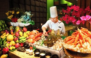 Exhibición de mariscos con diversos tipos de crustáceos y un chef preparando comida.