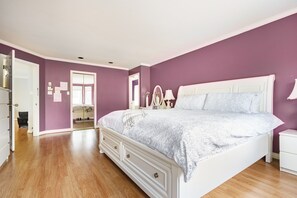 A bedroom with a large bed, a nightstand, a dresser, and a mirror. - Fraser River Richmond Bed & Breakfast (Richmond)