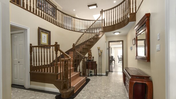 Una gran escalera de madera con diseño curvo que conduce a un piso superior.