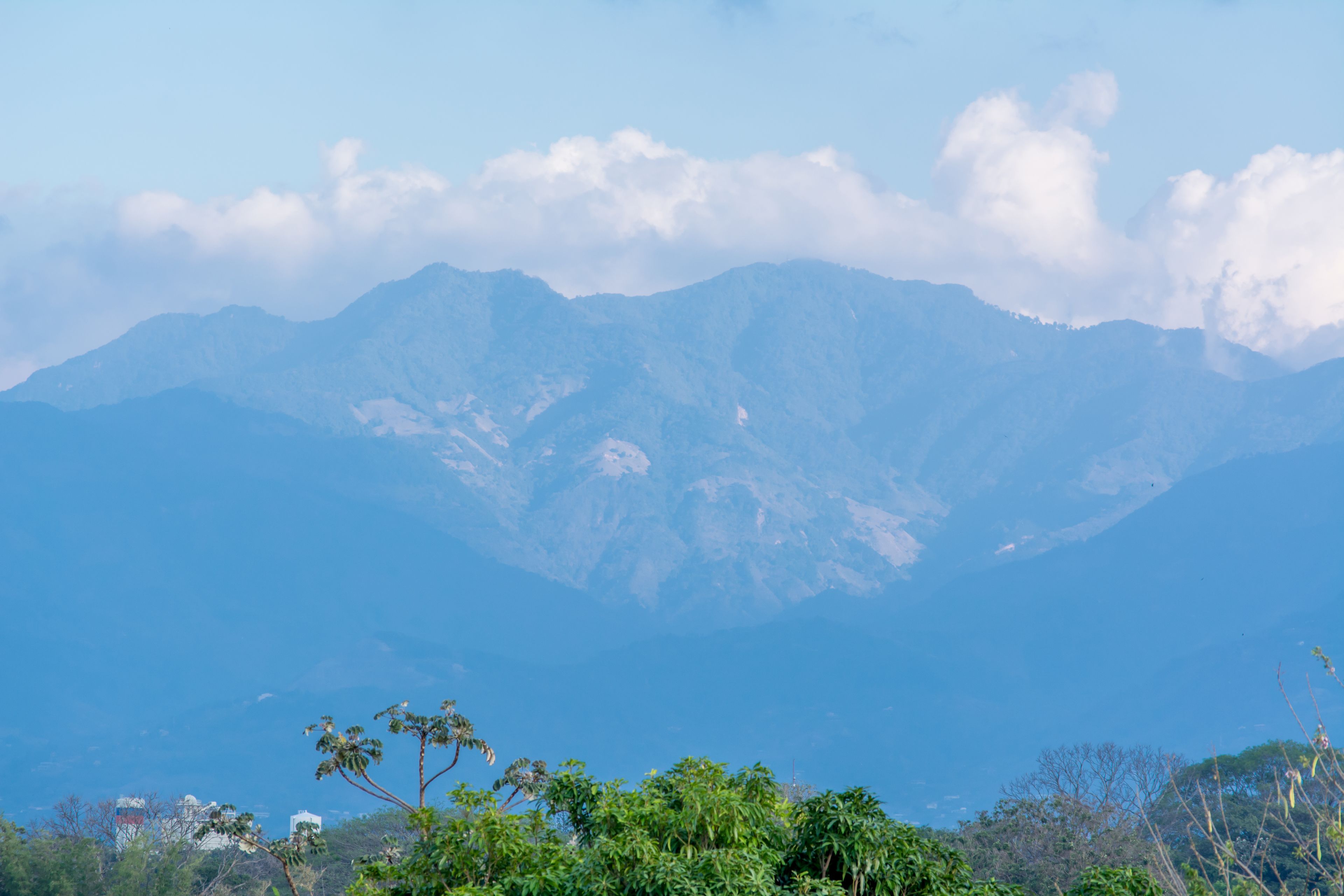 A mountainous landscape with a clear sky and some clouds.