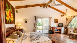 A bedroom with a bed, a desk, a chair, a television, and a view of the outdoors. - Villa Margarita (La Garita)