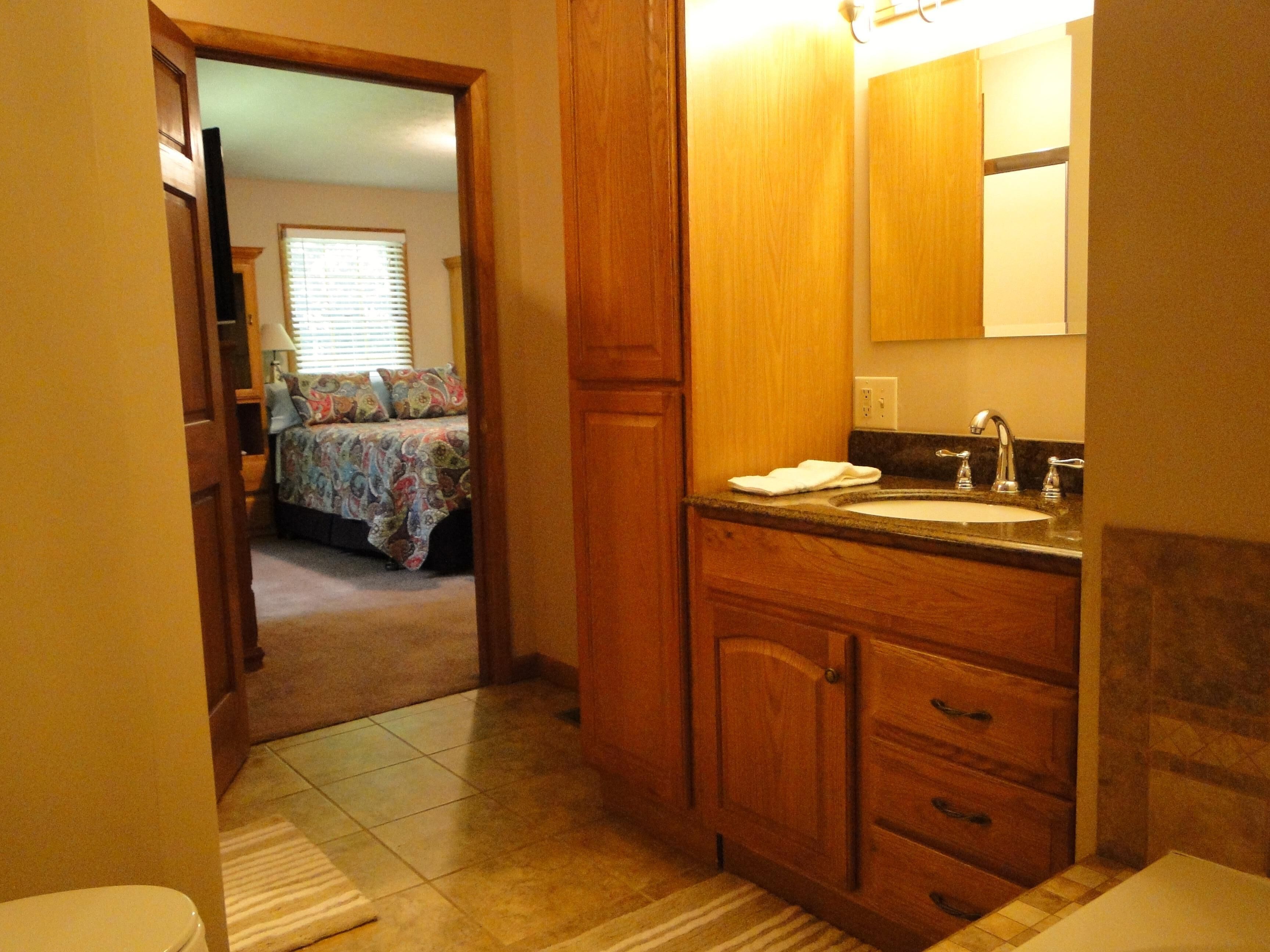 Une salle de bain avec des meubles en bois, un lavabo et un miroir.