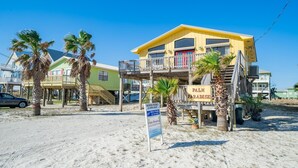 Una propiedad frente a la playa con un letrero que anuncia Palm Paradise, alquiler de casas de playa.