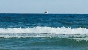 Un velero en el océano con olas acercándose a la costa.