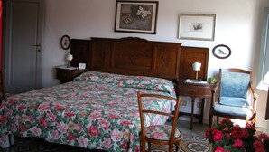 A bedroom with a wooden bed, a chair, a nightstand, and a dresser. - Attic with views in Piazza Santa Croce (Firenze)