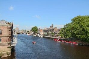 Une rivière avec des bateaux, un pont et des bâtiments le long des rives.