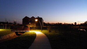 A house at dusk with a pathway leading to it, a bench, and a fence. - Apartment with Patio Centro de Ovar (Ovar)