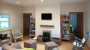 A cozy living room with a fireplace, bookshelves, and comfortable seating.