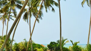 Ein Swimmingpool mit einer Person, die auf einem Luftreifen treibt, umgeben von Palmen und blauem Himmel.