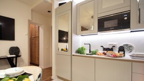 A modern kitchen with white cabinetry, a Bosch microwave, and a countertop with fresh produce and bread. - Tuscany Viareggio exclusive beachfront apartment   (Viareggio)