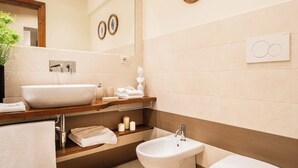A modern bathroom with a large mirror, a sink, a bidet, and a toilet. - Tuscany Viareggio exclusive beachfront apartment   (Viareggio)