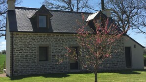 Un bâtiment en pierre avec un toit à pignon et une cheminée.