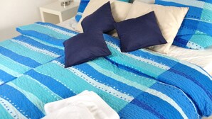 A bed with a blue and white striped bedspread, two pillows, and a white towel. - Beautiful, natural flat with big terrace in the heart of the island of Rügen (Patzig)