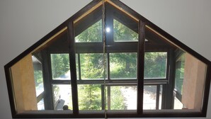 A room with a large, dark-framed window overlooking a green, wooded area. - Chalet at the foot of the slopes and 5 minutes from shops and ski school (Vars)