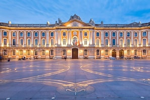 Un grand bâtiment historique doté d’une cour intérieure, de colonnes et d’une entrée imposante.