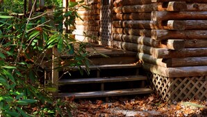 A rustic log cabin with a wooden porch and steps leading to the entrance. - Stay WATERFRONT !   Stay CHEAT RIVER LODGE (Elkins)