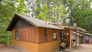 Une cabane rustique avec une façade en bois, une véranda et une cheminée.