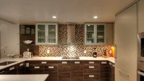 Une cuisine moderne avec des meubles en bois foncé, un îlot central et un revêtement mural décoré de motifs en mosaïque.