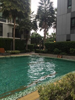 Alberca al aire libre, sombrillas en la alberca y camastros 