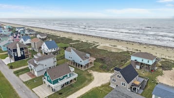 Een kustwoongebied met huizen, een strand en een heldere lucht.