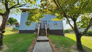 A two-story building with a concrete pathway leading to the entrance.